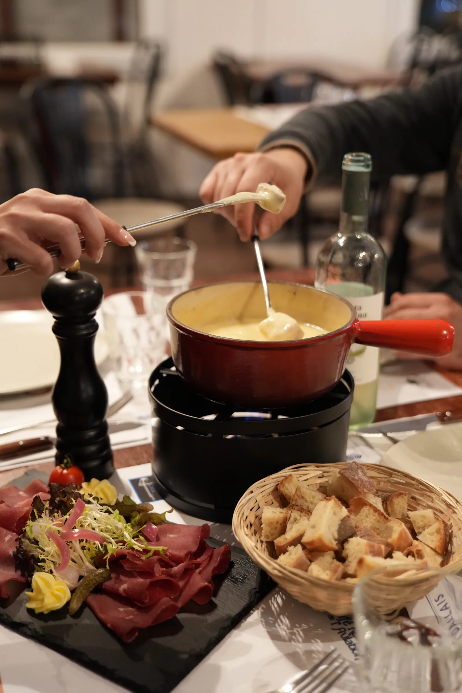 A table gathered around the fondue pot, with air-dried meat and bread