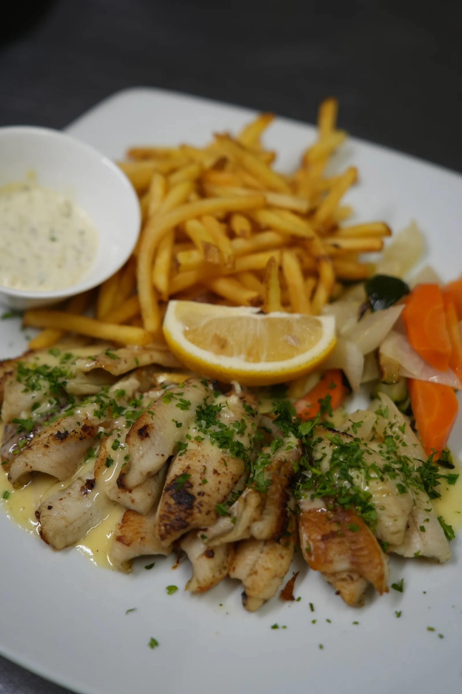 Filets de perche au beurre citronné, frites et légumes