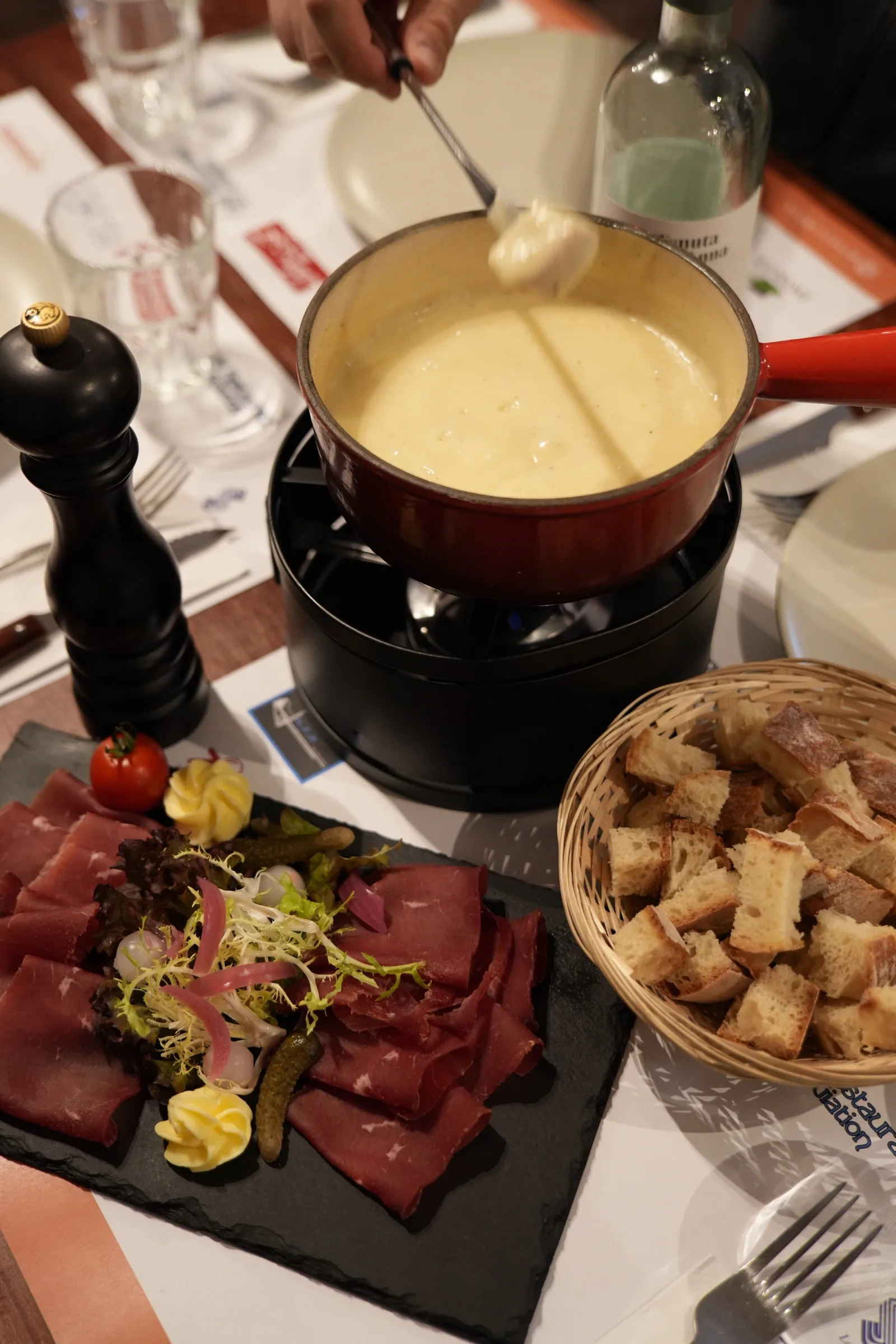 Half-and-half fondue, a plate of air-dried meat and a basket of bread