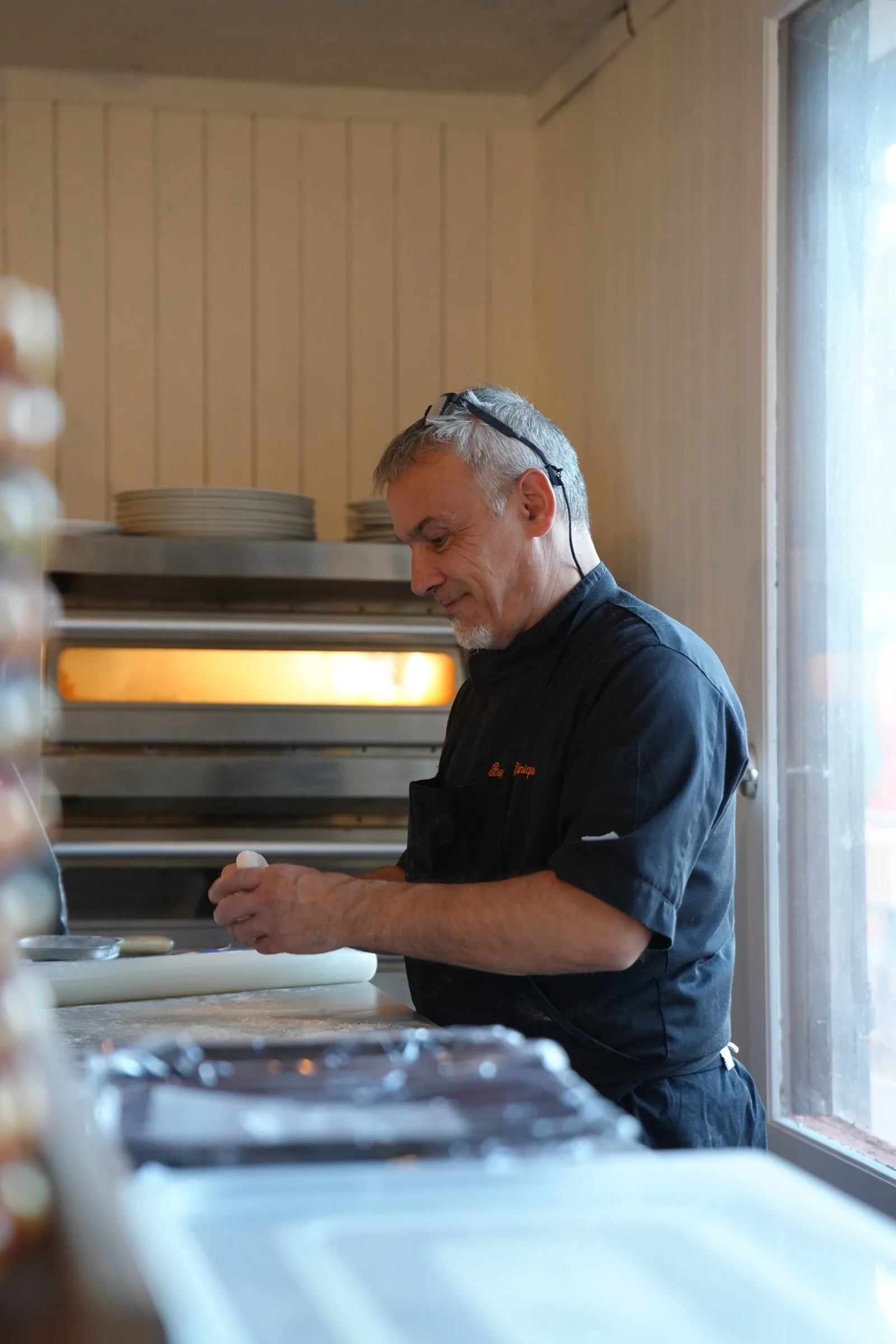 Le chef en cuisine, devant le four à pizzas